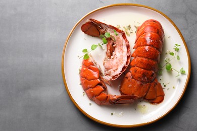 Photo of Delicious tails of boiled lobsters served on grey table, top view. Space for text