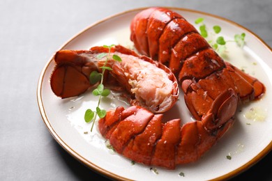 Delicious tails of boiled lobsters served on grey table, closeup