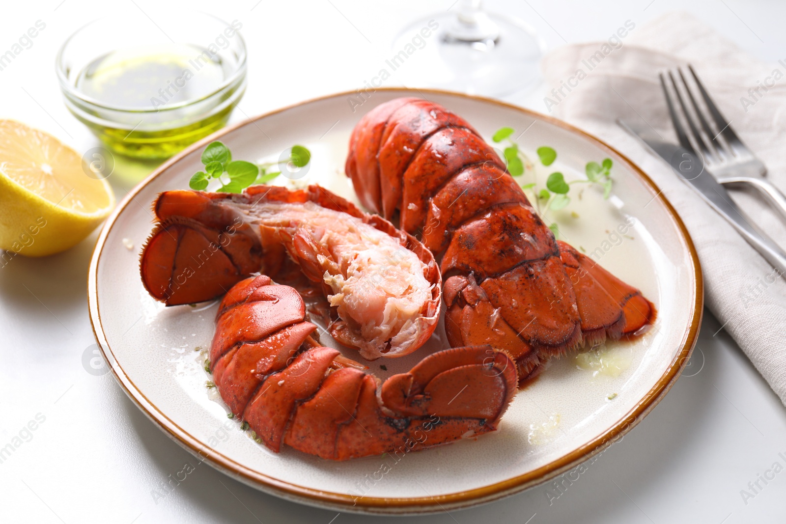 Photo of Delicious tails of boiled lobsters served on white table, closeup