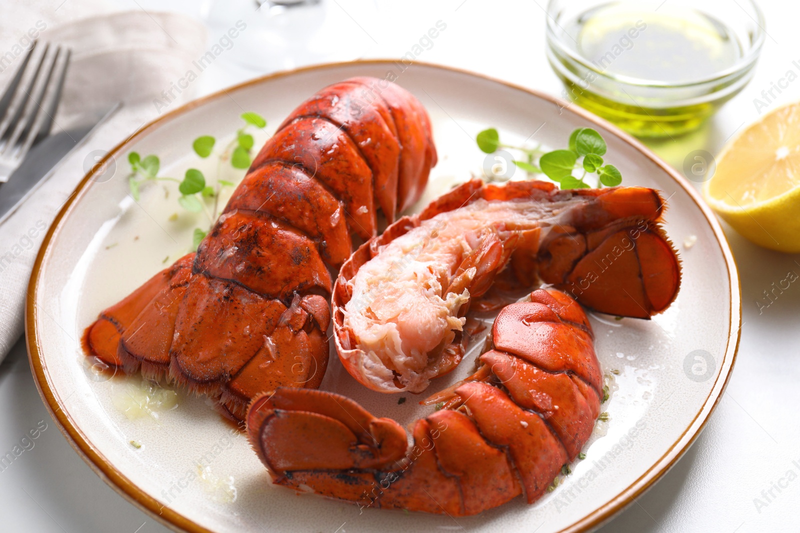 Photo of Delicious tails of boiled lobsters served on white table, closeup