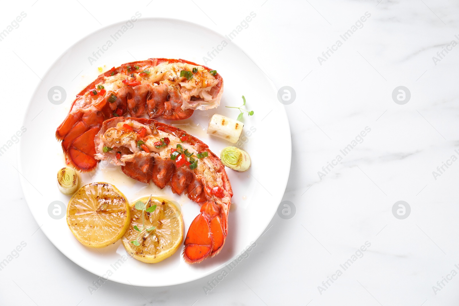 Photo of Delicious lobster tails with lemon, microgreens and green onion on white marble table, top view. Space for text