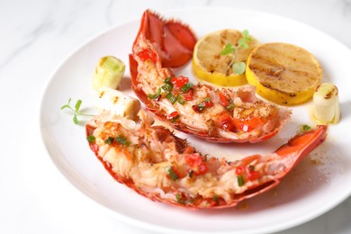 Photo of Delicious lobster tails with lemon, microgreens and green onion on white table, closeup