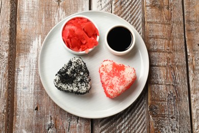 Photo of Tasty tobiko onigiri (Japanese rice balls) served on wooden table, top view