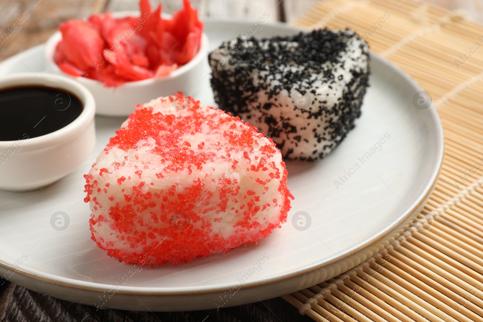 Photo of Tasty tobiko onigiri (Japanese rice balls) served on table, closeup