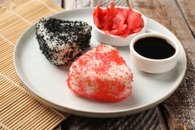 Photo of Tasty tobiko onigiri (Japanese rice balls) served on wooden table, closeup