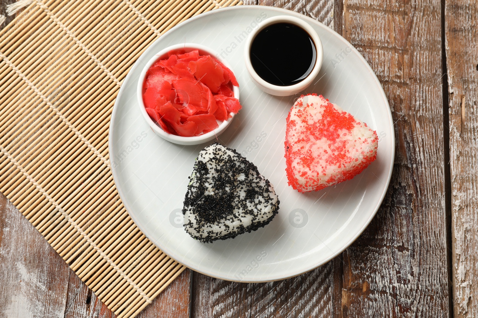 Photo of Tasty tobiko onigiri (Japanese rice balls) served on wooden table, top view