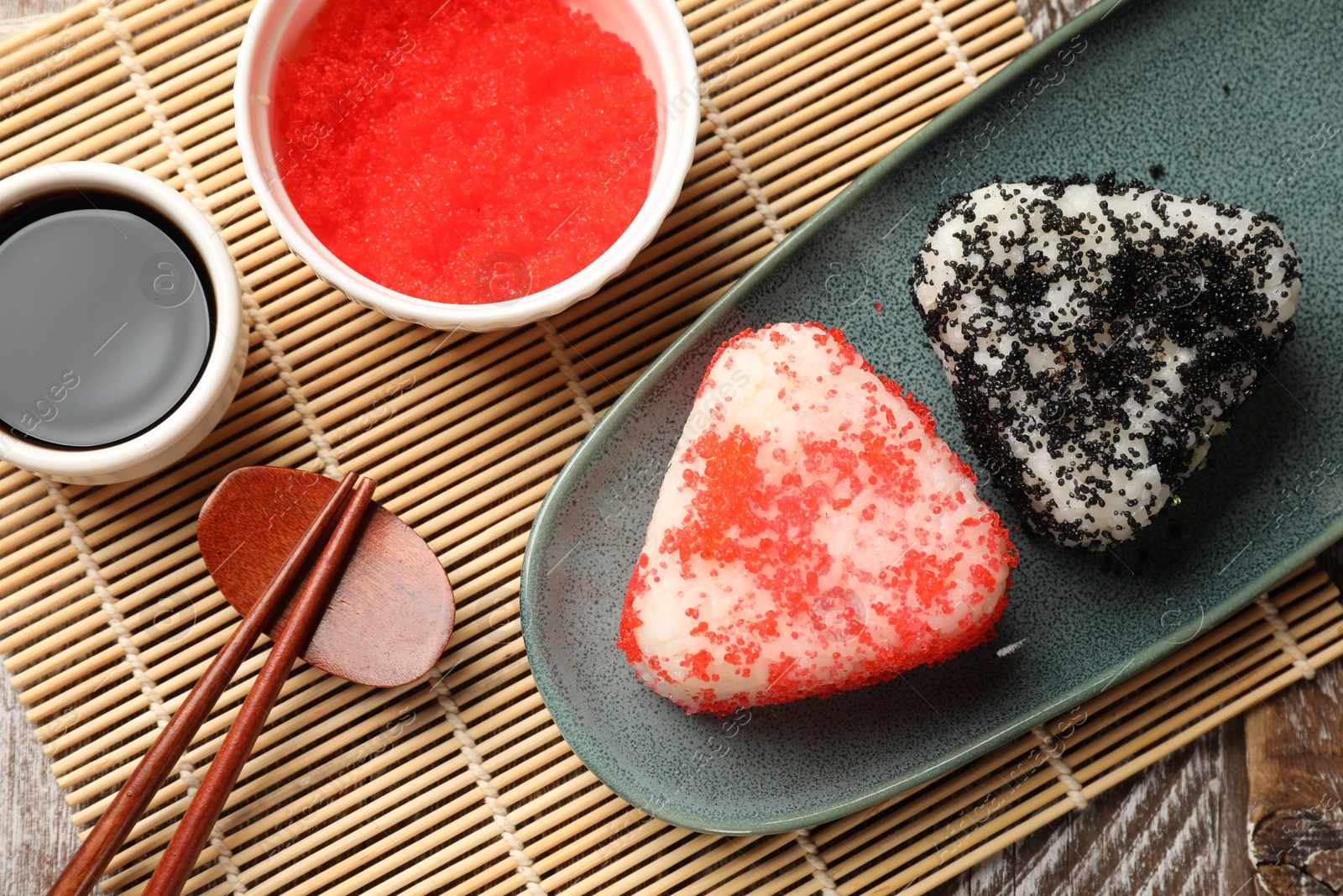 Photo of Tasty tobiko onigiri (Japanese rice balls) served on table, flat lay