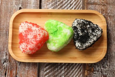 Photo of Tasty tobiko onigiri (Japanese rice balls) served on wooden table, top view