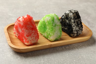 Photo of Tasty tobiko onigiri (Japanese rice balls) served on grey table, closeup