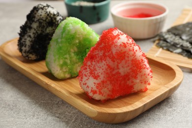 Photo of Tasty tobiko onigiri (Japanese rice balls) served on grey table, closeup