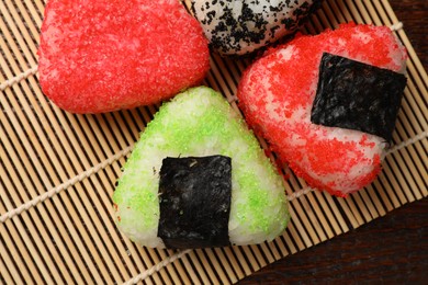 Photo of Tasty tobiko onigiri (Japanese rice balls) served on wooden table, top view