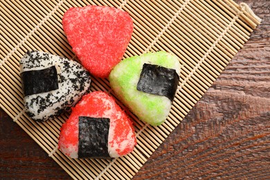 Photo of Tasty tobiko onigiri (Japanese rice balls) served on wooden table, top view