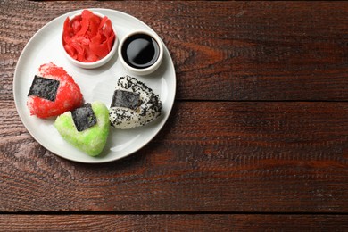 Photo of Tasty tobiko onigiri (Japanese rice balls) served on wooden table, top view