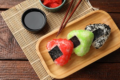 Photo of Tasty tobiko onigiri (Japanese rice balls) served on wooden table, flat lay