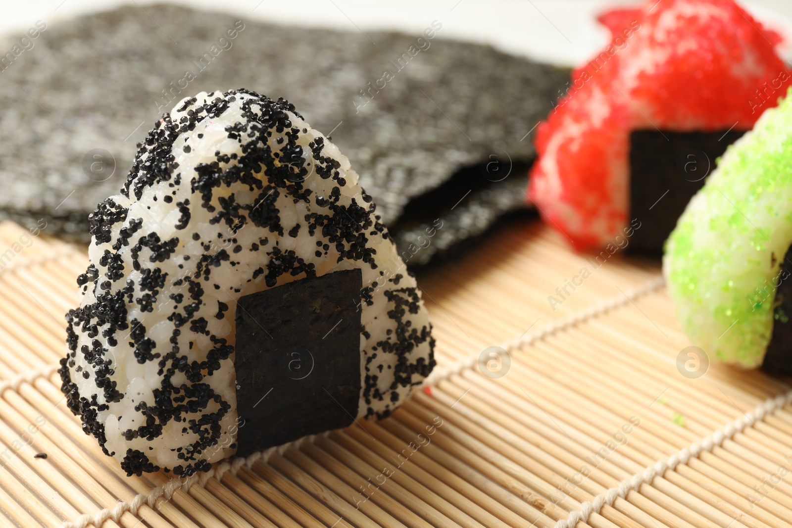 Photo of Tasty tobiko onigiri (Japanese rice balls) served on table, closeup