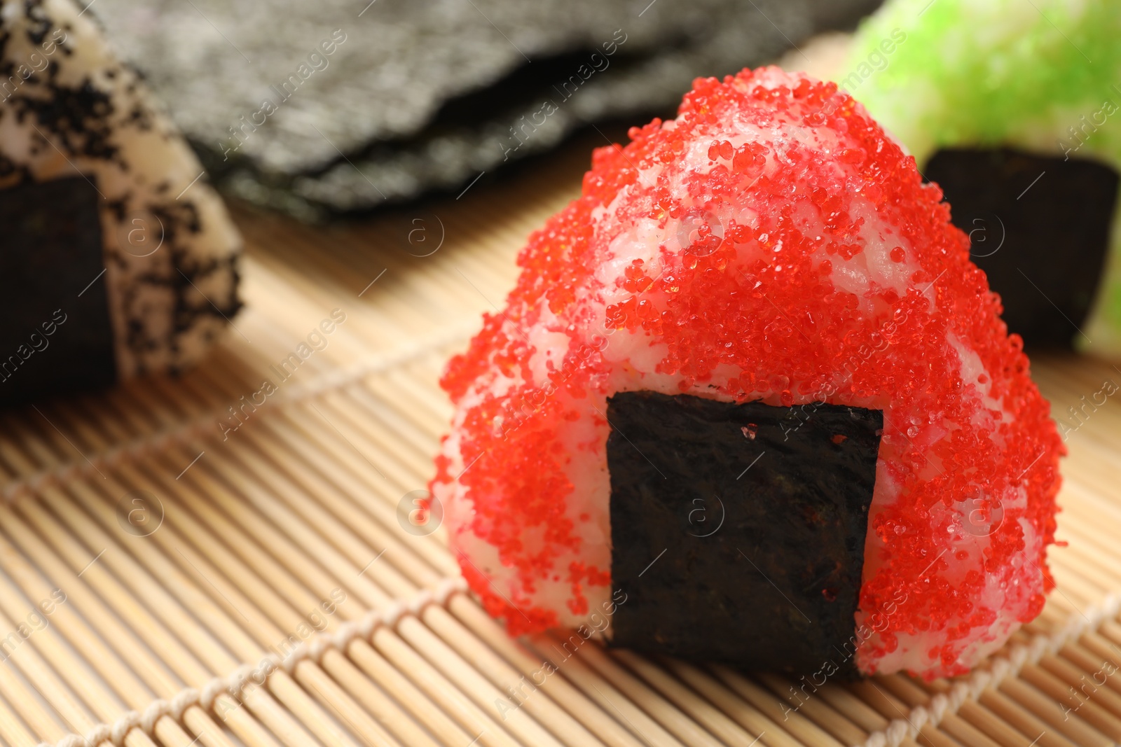 Photo of Tasty tobiko onigiri (Japanese rice balls) served on table, closeup