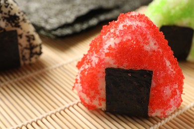 Photo of Tasty tobiko onigiri (Japanese rice balls) served on table, closeup