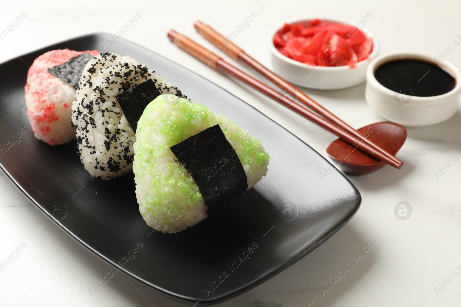 Photo of Tasty tobiko onigiri (Japanese rice balls) served on white table, closeup