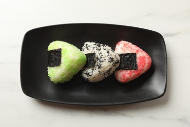 Photo of Tasty tobiko onigiri (Japanese rice balls) served on white table, top view