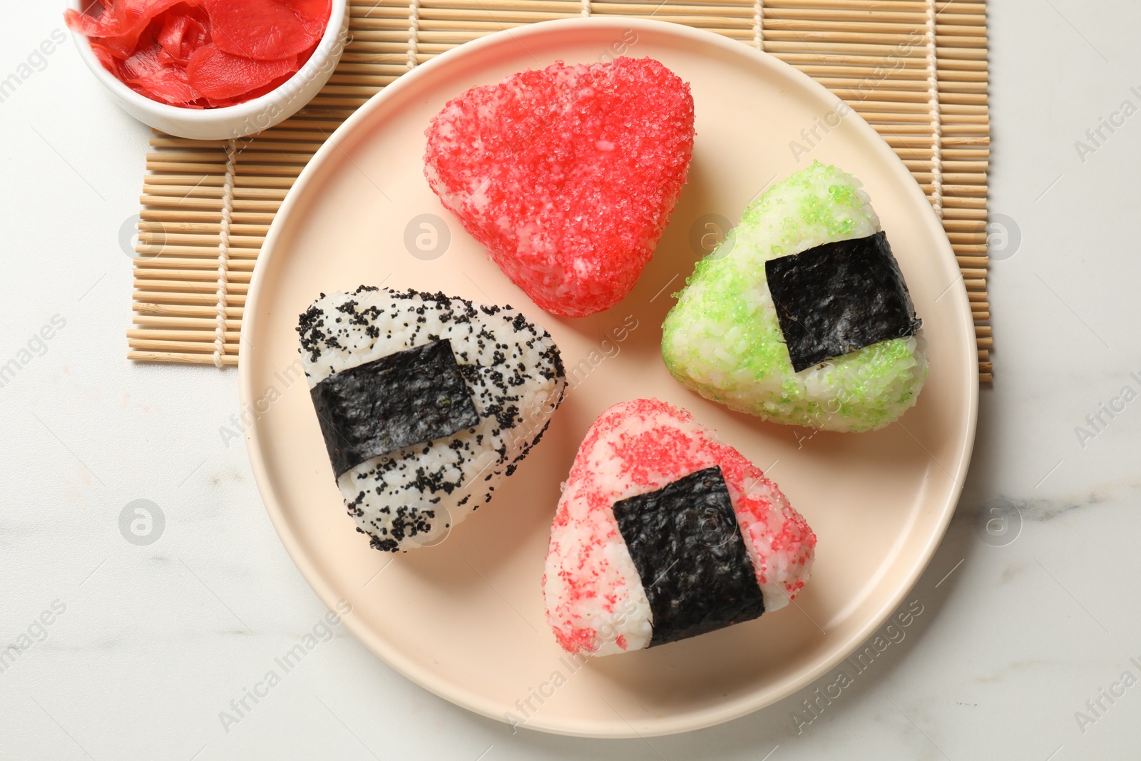 Photo of Tasty tobiko onigiri (Japanese rice balls) served on white table, top view