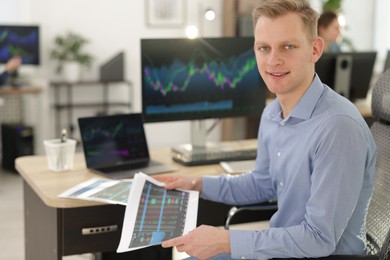 Photo of Stock exchange. Man working at desk in office