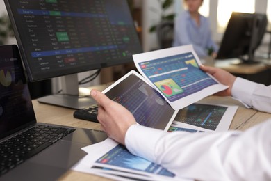 Photo of Stock exchange. Man working at desk in office, closeup