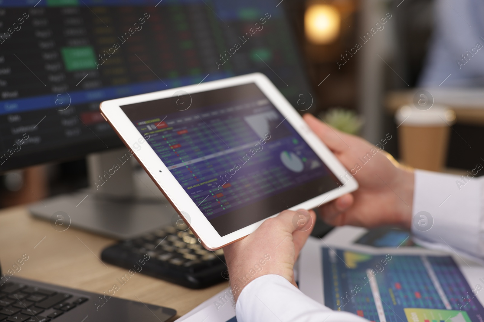 Photo of Stock exchange. Man working at desk in office, closeup