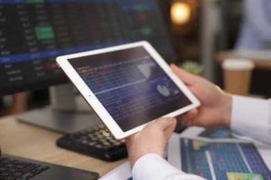 Photo of Stock exchange. Man working at desk in office, closeup