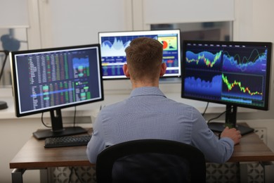 Photo of Stock exchange. Man working at desk in office, back view