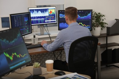 Photo of Stock exchange. Man working at desk in office, back view