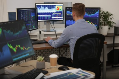 Photo of Stock exchange. Man working at desk in office, back view