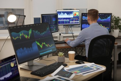 Photo of Stock exchange. Man working at desk in office, back view