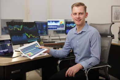 Photo of Stock exchange. Man working at desk in office