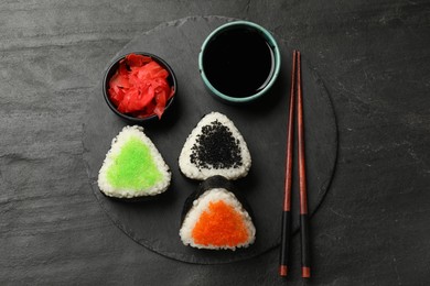 Photo of Tasty tobiko onigiri (Japanese rice balls) served on black table, flat lay