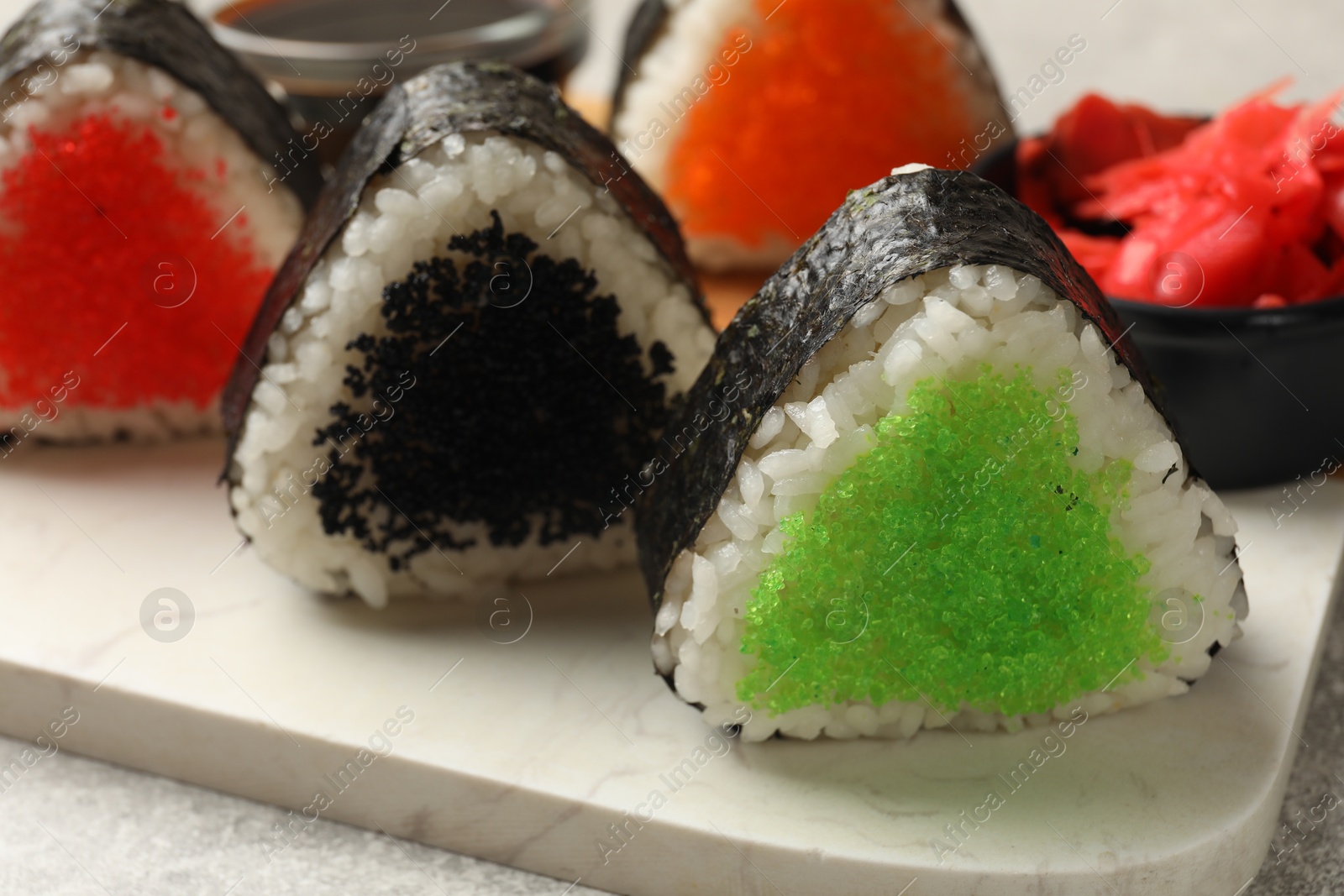 Photo of Tasty tobiko onigiri (Japanese rice balls) on table, closeup