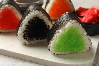 Photo of Tasty tobiko onigiri (Japanese rice balls) on table, closeup