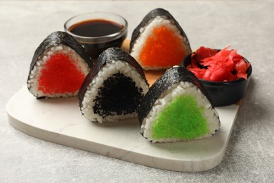 Photo of Tasty tobiko onigiri (Japanese rice balls) served on light grey table, closeup