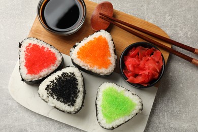 Photo of Tasty tobiko onigiri (Japanese rice balls) served on light grey table, top view