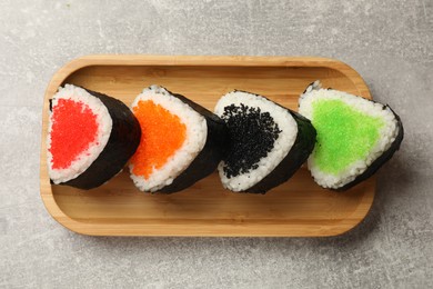 Photo of Tasty tobiko onigiri (Japanese rice balls) on light grey table, top view