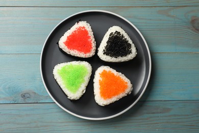 Photo of Tasty tobiko onigiri (Japanese rice balls) on light blue wooden table, top view