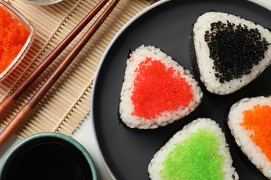 Photo of Tasty tobiko onigiri (Japanese rice balls) served on table, flat lay