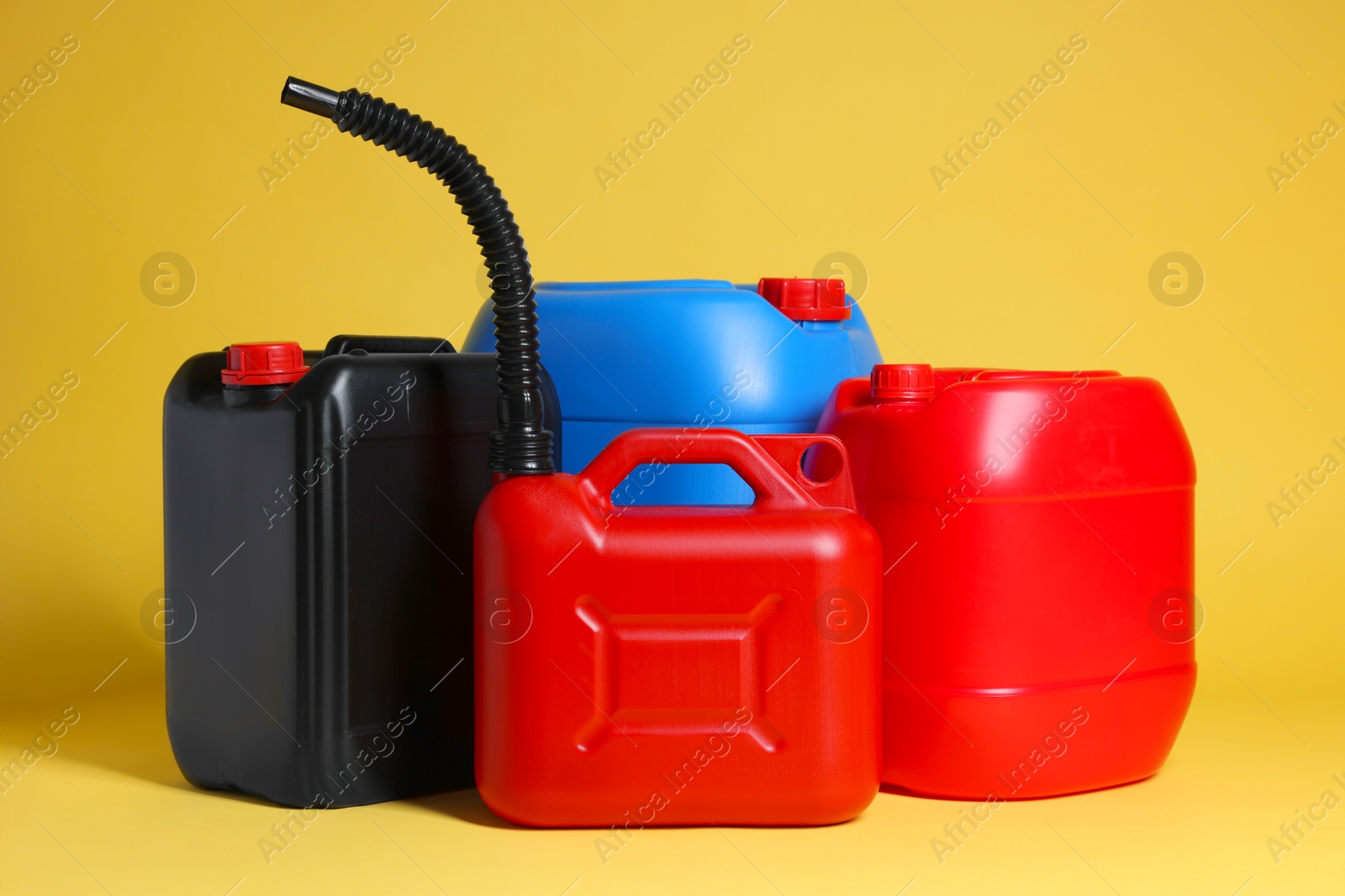 Photo of Many different plastic canisters on yellow background