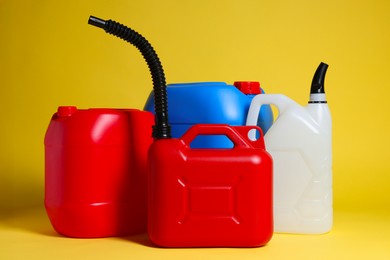 Photo of Many different plastic canisters on yellow background