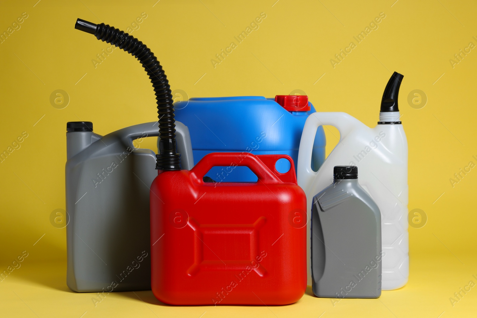 Photo of Many different plastic canisters on yellow background