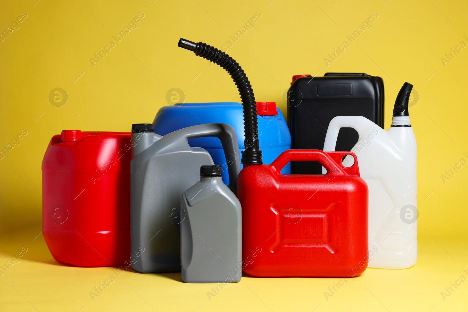 Photo of Many different plastic canisters on yellow background