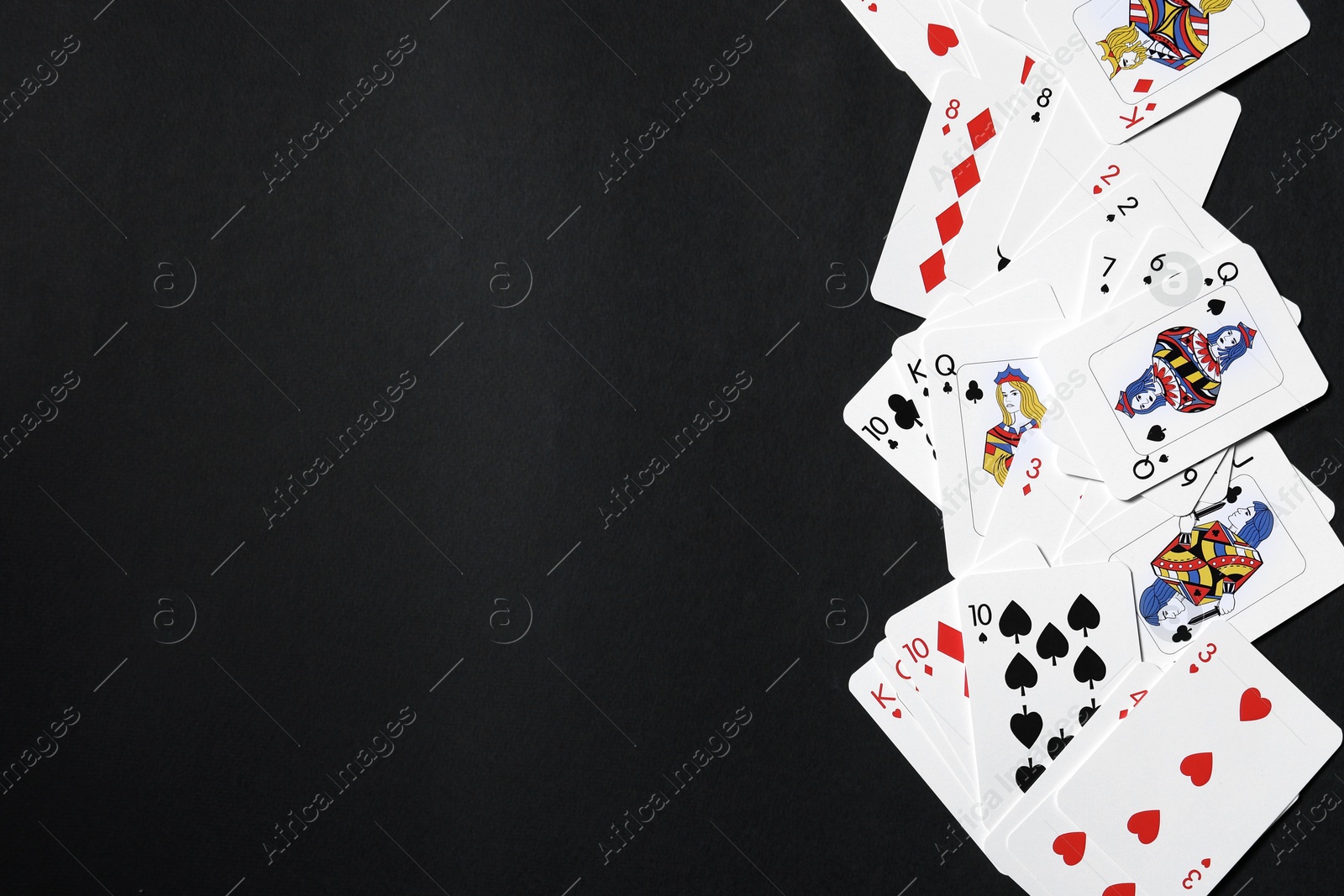 Photo of Playing cards on black background, top view. Space for text