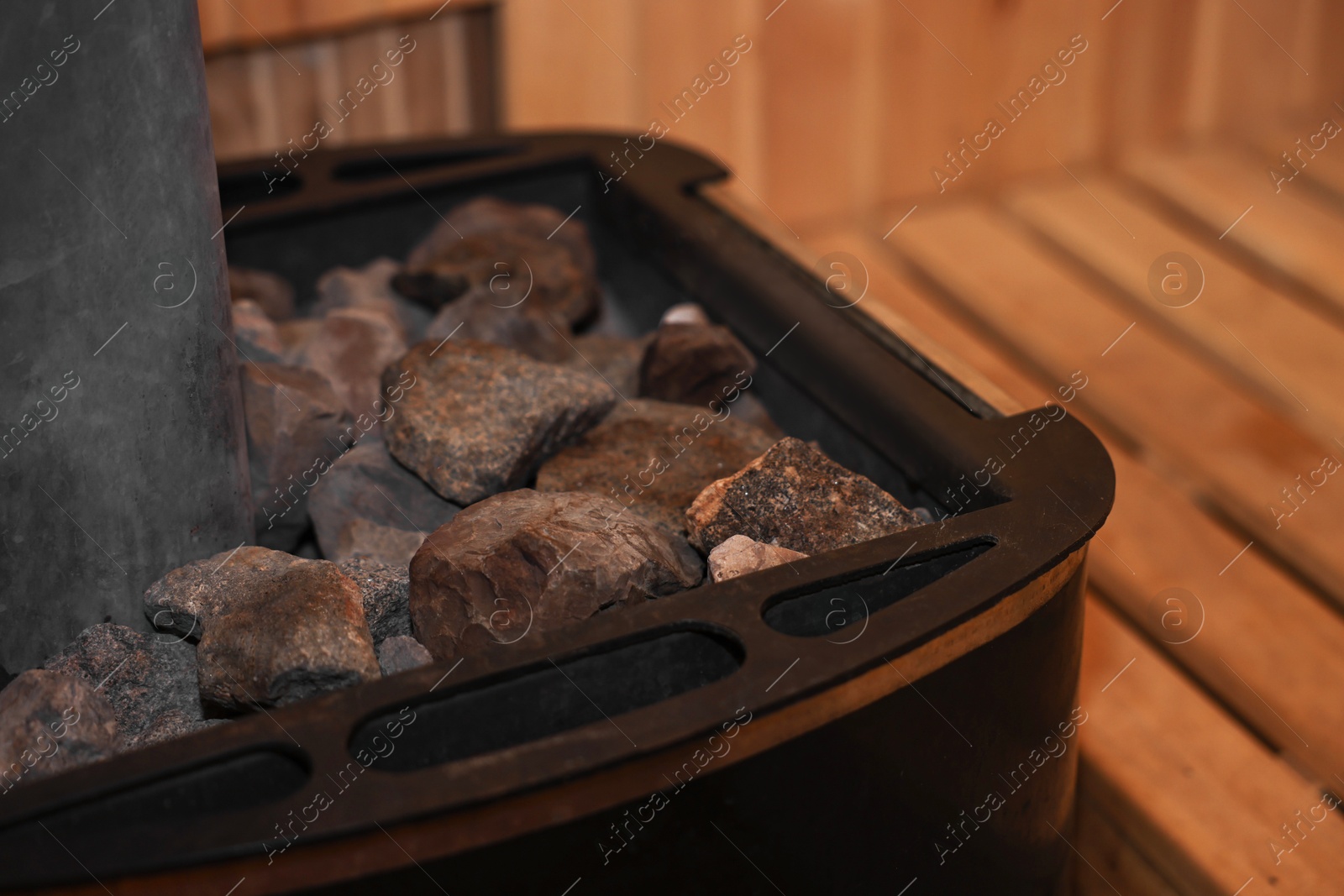 Photo of Stove with hot rocks in sauna, closeup