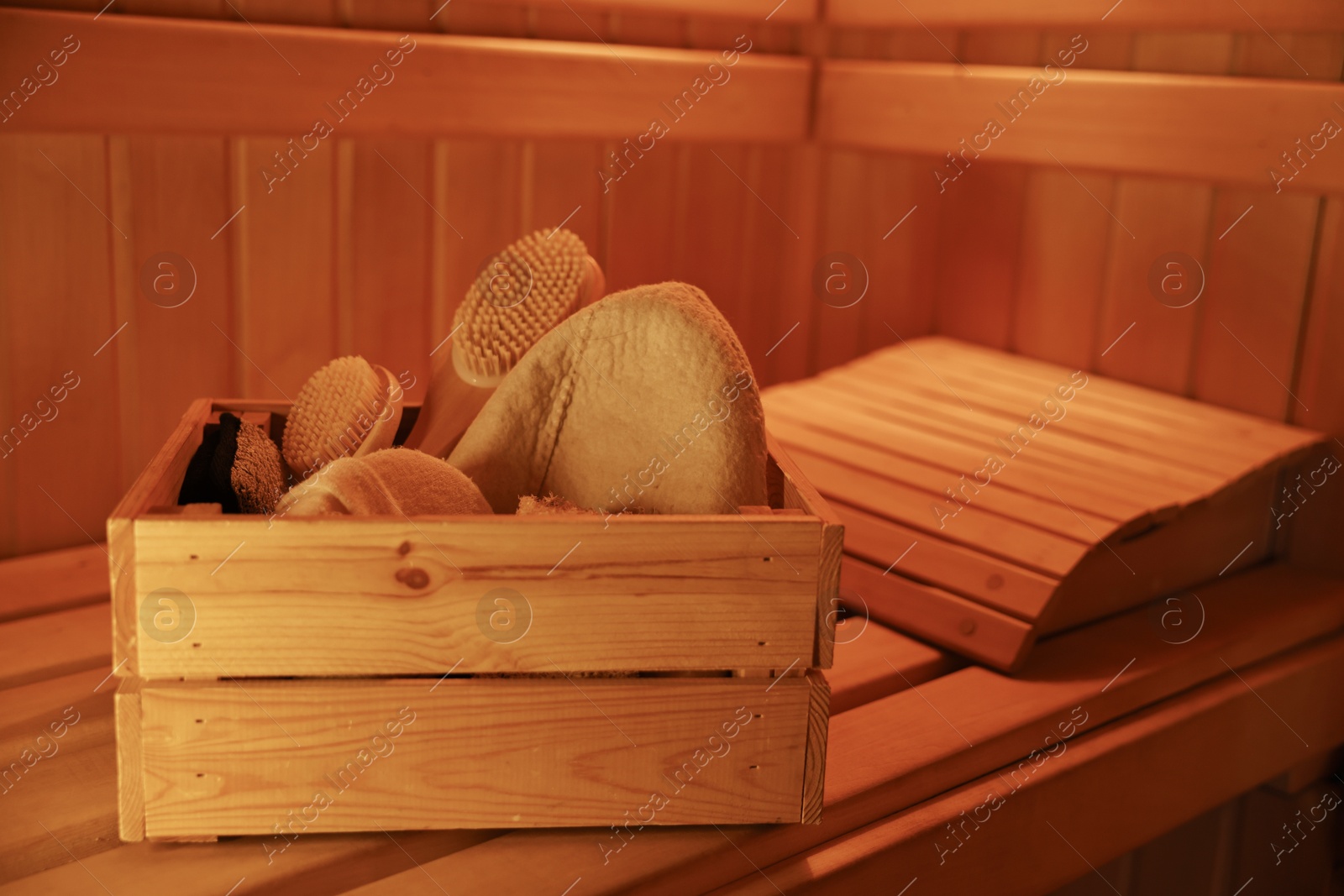 Crate with bath accessories on bench in sauna Photo of Crate with bath accessories on bench in sauna