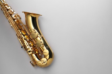 Photo of Jazz. One saxophone on light grey background, top view. Space for text