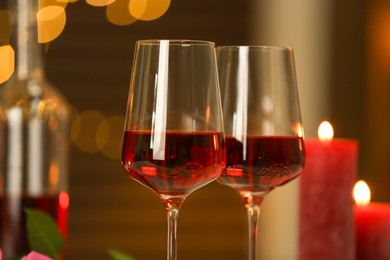 Photo of Glasses of red wine against blurred background, closeup. Romantic dinner